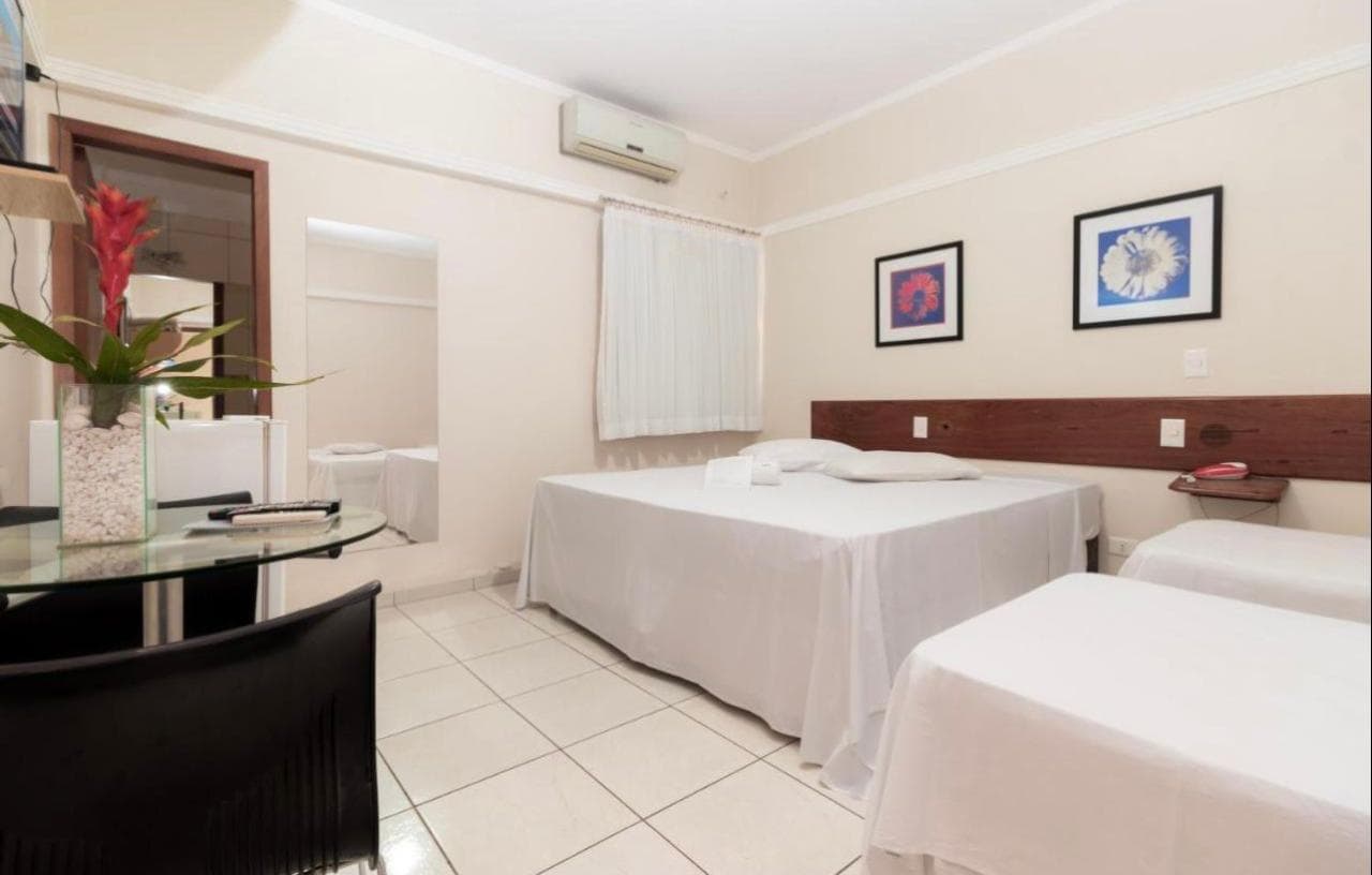 Quarto com cama de casal e duas de solteiro