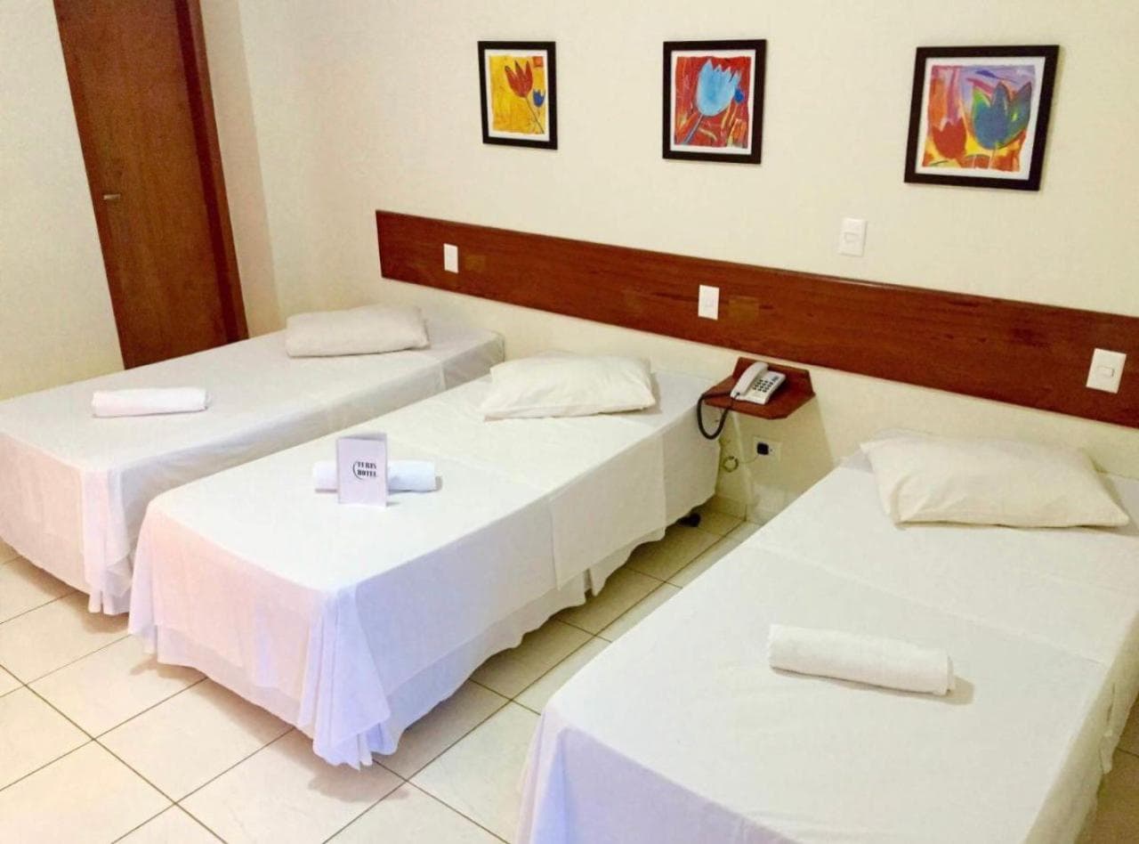 Quarto com três camas de solteiro